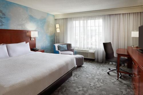 渥太華的住宿－渥太華市區萬怡酒店，酒店客房,配有一张床、一张桌子和椅子