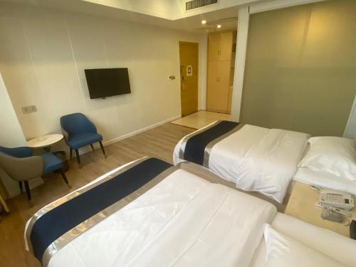 a hospital room with two beds and a tv at Green Island Holiday Hotel in Jiangmen