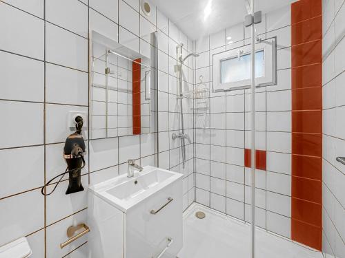 ein weißes Badezimmer mit Waschbecken und Spiegel in der Unterkunft Le Petit Torcieu in Torcieu