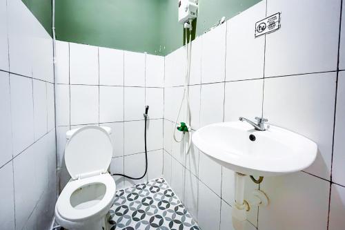 a bathroom with a toilet and a sink at Citara Jaya Guesthouse Mitra RedDoorz in Bekasi