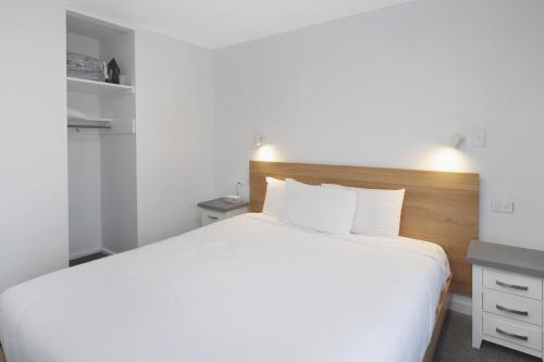 a bedroom with a large white bed and a desk at The Adelphi in Christchurch