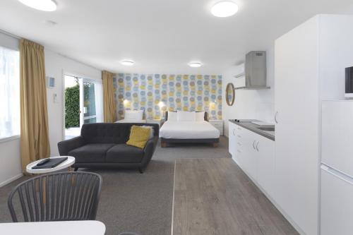 a living room with a couch and a kitchen at The Adelphi in Christchurch