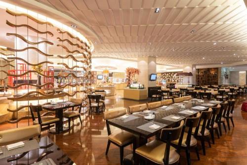 a restaurant with tables and chairs in a room at Pullman Foshan Shunde-Canton Fair Shuttle Bus at Extra RMB100 per Person Daily in Shunde