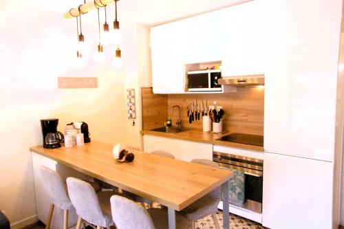 une cuisine avec une table et des chaises en bois dans l'établissement Comfortable apartment with pool, à Moliets-et-Maa