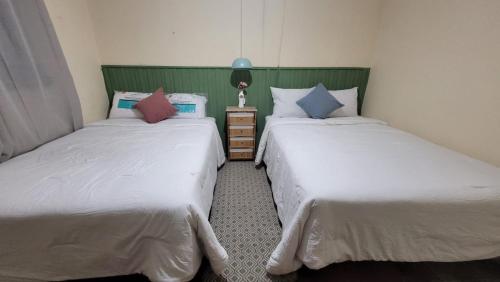 2 Betten nebeneinander in einem Zimmer in der Unterkunft Hostal Casa Antigua Santa Ana in Santa Ana