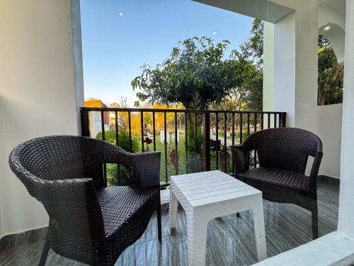 two chairs and a table on a balcony at Golden Mango By Food Bunglow in Rāmnagar