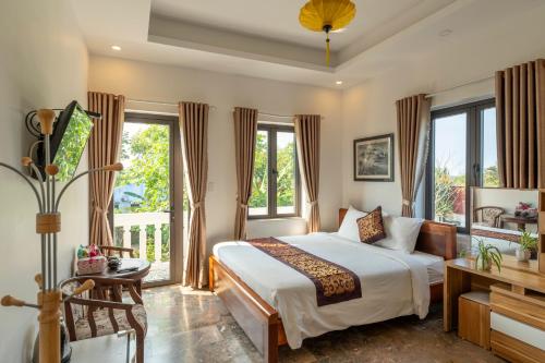 um quarto com uma cama e uma varanda em Rice River Villa - Hoi An em Hoi An