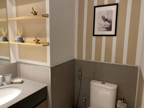 a bathroom with a white toilet and a sink at Indigo beach residence 110 in Sharjah