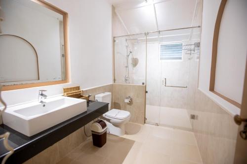 uma casa de banho com um lavatório, um WC e um chuveiro em Sigiriya Village em Sigiriya