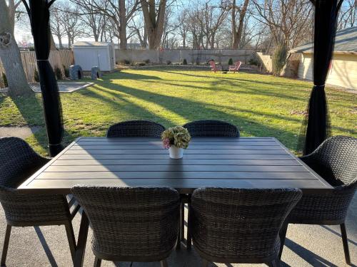 a wooden table with chairs and a potted plant on it at Peaceful 4BDRM Home 5mins to Clifton Hill in Niagara Falls