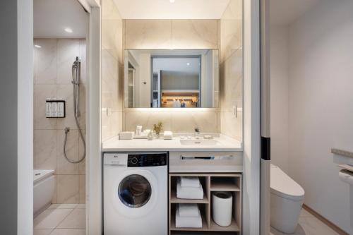 a bathroom with a washing machine and a sink at Hyatt House Tokyo Shibuya in Tokyo