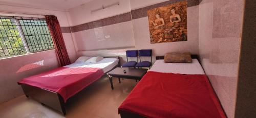 Zimmer mit 2 Betten und einem Fenster in der Unterkunft RMS cottage in Yercaud