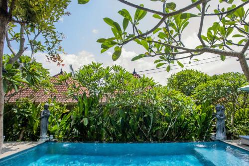 a swimming pool in front of a house with trees at 221 Garden Cottages in Nusa Lembongan