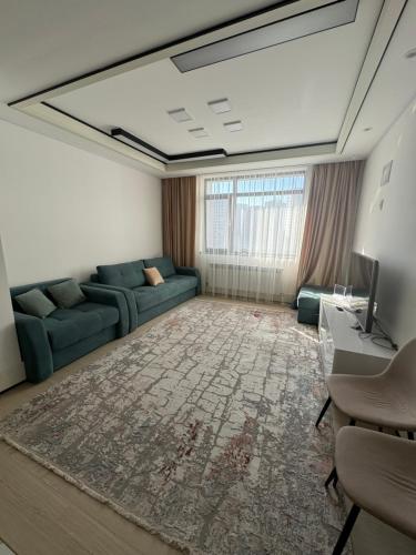 sala de estar con sofá y TV en Highvill Ishim, en Astana