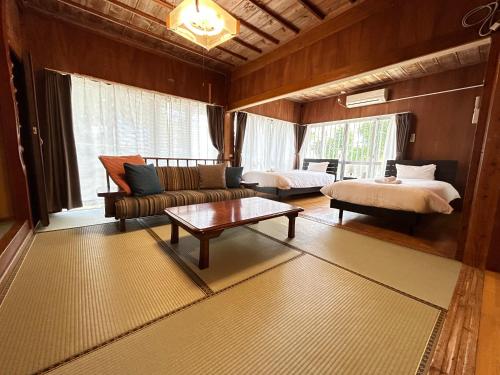 een woonkamer met een bank, een bed en een tafel bij Guest House Renga in Henza