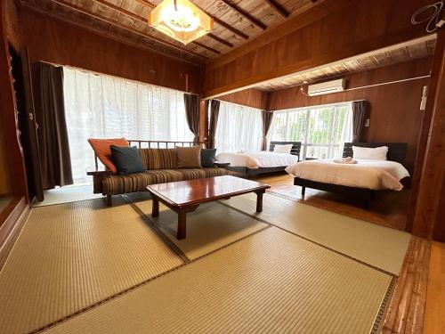 a living room with a couch and a bed and a table at Guest House Renga in Henza