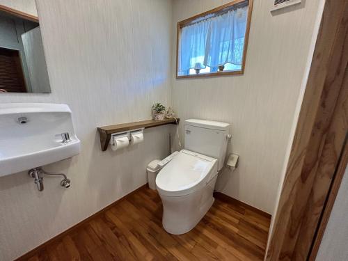 a bathroom with a toilet and a sink and a window at Guest House Renga in Henza