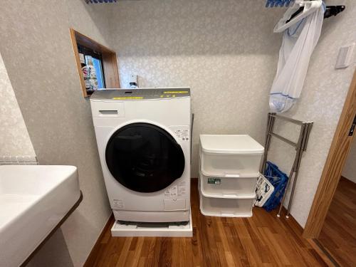een wasmachine en droger in de hoek van een kamer bij Guest House Renga in Henza