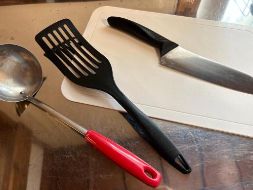 a black fork and knife sitting on a cutting board at Guest House Renga in Henza