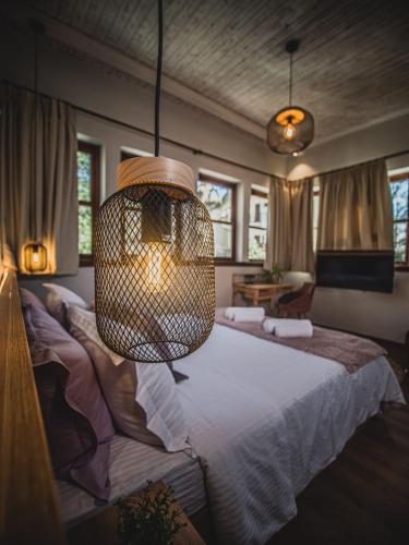 a bedroom with a large bed with a chandelier at Αρχοντικό Πορταριάς in Portariá
