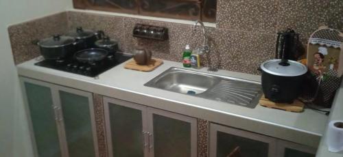 a kitchen sink with pots and pans on it at AlojaRous2 in Tingo María