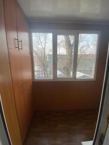 Habitación vacía con 2 ventanas y pasillo en 1 комнатная квартира на Райымбека 167а, en Almaty