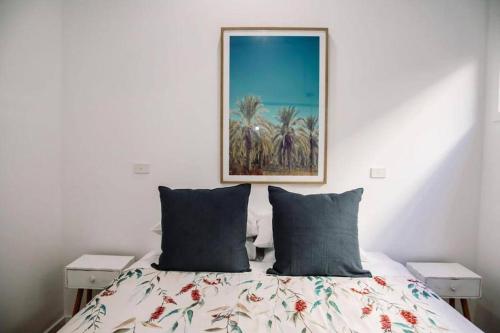 a bedroom with a bed with a painting on the wall at Rail View Stay Timboon in Timboon