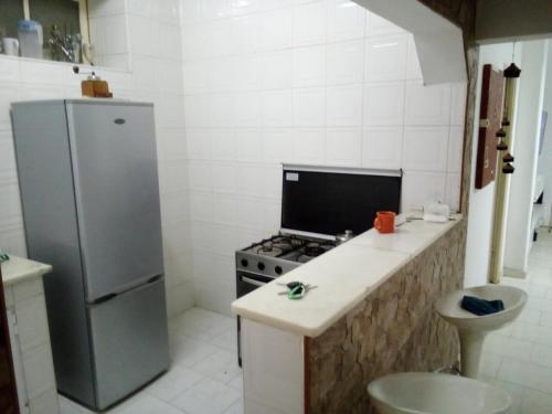 a small kitchen with a stove and a refrigerator at Borges Place in Praia