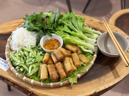 胡志明市的住宿－Home Tea An Yên Dorm，桌上的盘子,配面条和蔬菜