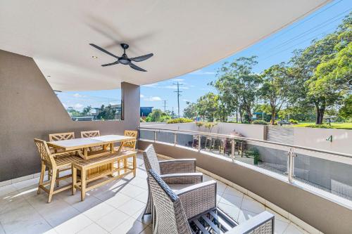 a balcony with a table and chairs and a ceiling fan at The Inlet in North Haven