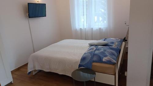 a bedroom with a bed and a tv on a wall at Kleine gemütliche Wohnung mit überdachter Terrasse in Łukta