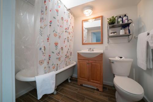 een badkamer met een toilet, een bad en een wastafel bij Carriage House in Denver