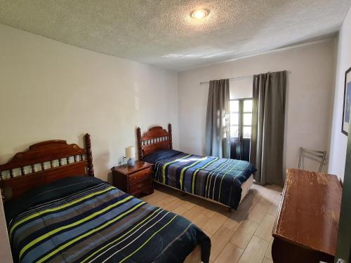 a bedroom with two beds and a window at Hermosa casa en el centro de Zacatecas in Zacatecas