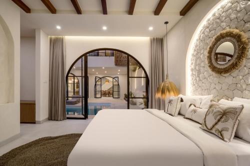 um quarto com uma grande cama branca e um espelho em Villa Balmoral Canggu em Canggu