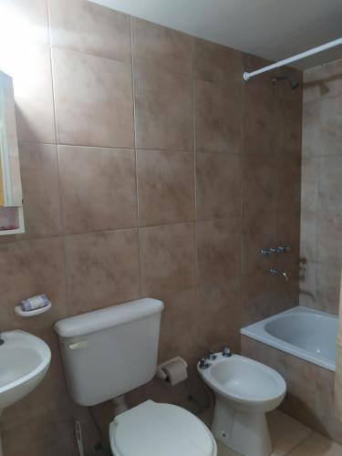 a bathroom with a toilet and a sink and a tub at Alquiler Temporario Tucumán Con Cochera Y Pileta in San Miguel de Tucumán