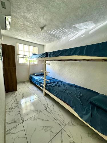 a bedroom with two bunk beds and a window at Departamento Acapulco frente a la playa in Acapulco