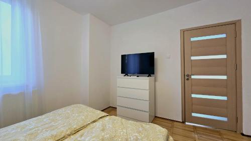 a small bedroom with a bed and a television at Apartament Confort Hd in Hunedoara