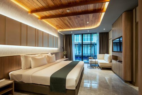 a hotel room with a bed and a chair at Luminous Resort & Spa by Areca in Phuket Town