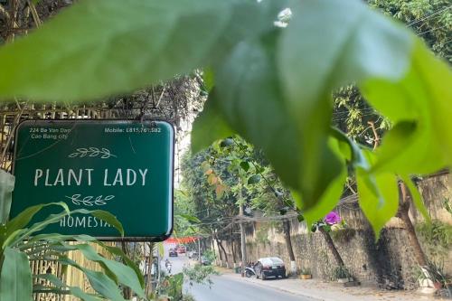 a green plant lady sign on the side of a road at Plant Lady Homestay Cao Bằng in Cao Bằng