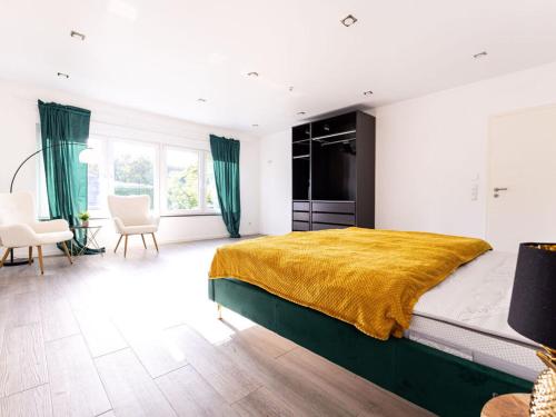 a bedroom with a large bed with a yellow blanket at Apartment for 6 Modern retreat in Andernach