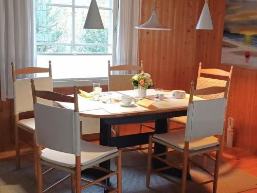 einen Esstisch mit Stühlen, einem Tisch, einem Tisch und einem Stuhl in der Unterkunft Glammseehaus Ulla Comfortable holiday residence in Warin