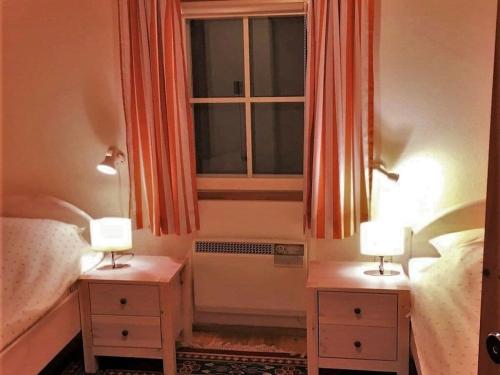 a bedroom with two lamps and a window at Glammseehaus Ulla Comfortable holiday residence in Warin