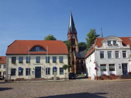 a group of buildings in a town with a church at Glammseehaus Ulla Comfortable holiday residence in Warin