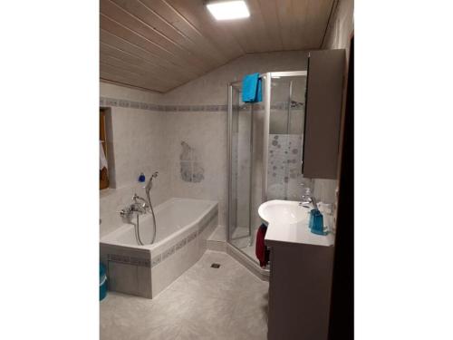 bagno con vasca e lavandino di Holiday apartment Maurer Apartment Laber a Oberammergau