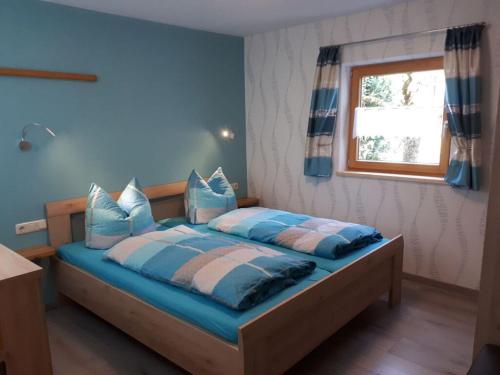 - une chambre avec un lit doté de draps bleus et une fenêtre dans l'établissement Holiday apartment Maurer Apartment Laber, à Oberammergau