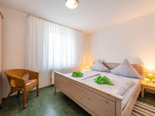 een slaapkamer met een bed met twee groene handdoeken erop bij Sea View 3 - Villa Bella Vista in Sassnitz