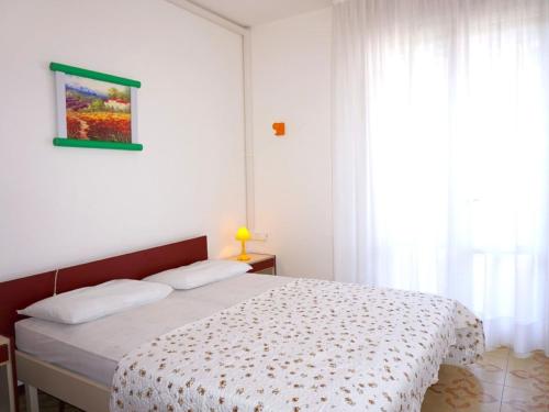 Schlafzimmer mit einem Bett und einem Fenster mit weißen Vorhängen in der Unterkunft Property in Porto Santa Margherita VE in Porto Santa Margherita