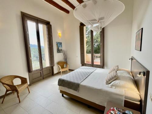 a bedroom with a large bed and large windows at Castle Apartment for 3-4 people with terrace in La Torre de Claramunt