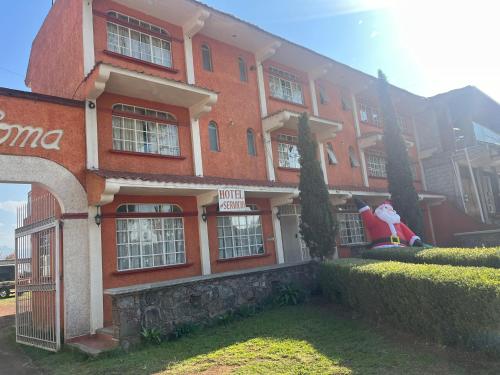 un edificio de ladrillo rojo con un letrero de Santa. en Hotel La Loma, en Huasca de Ocampo