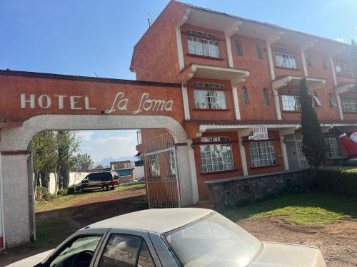 ein Auto, das vor einem Hotel la bomota parkt in der Unterkunft Hotel La Loma in Huasca de Ocampo